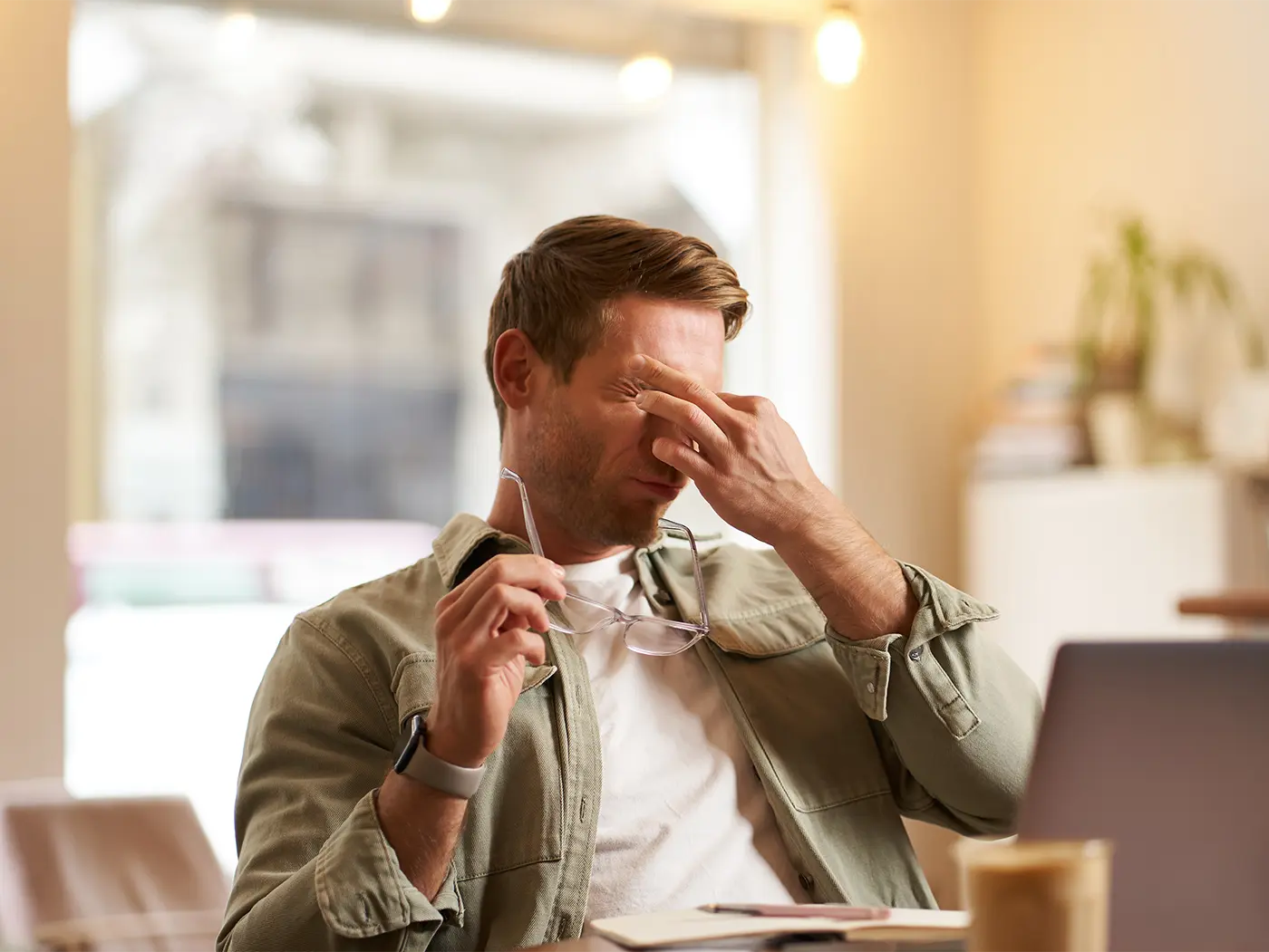 Homme fatigué se frottant les yeux devant son ordinateur en découvrant la résiliation de son contrat d’assurance auto